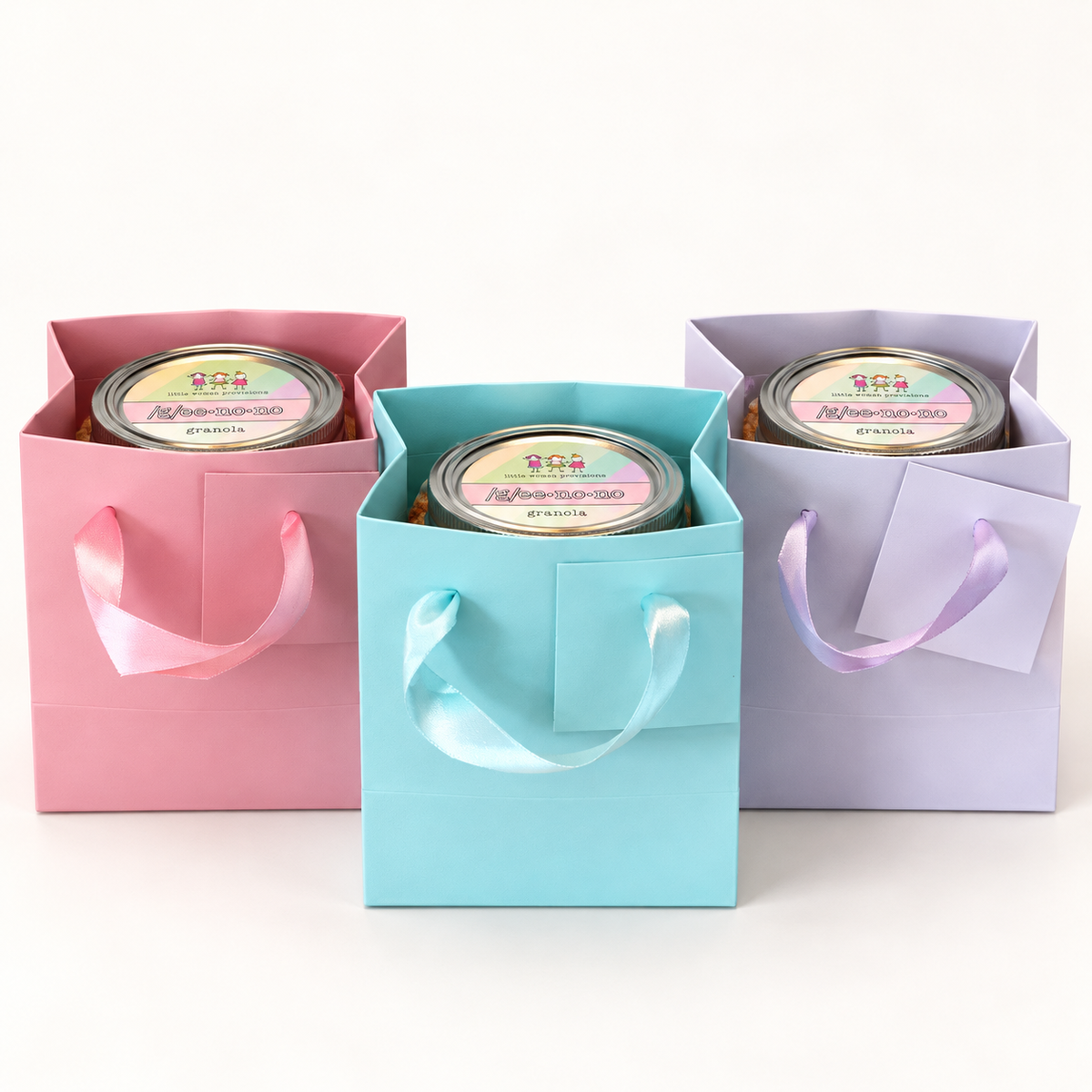 Three Geenono mini jars tucked into pink, aqua and lavender gift bags